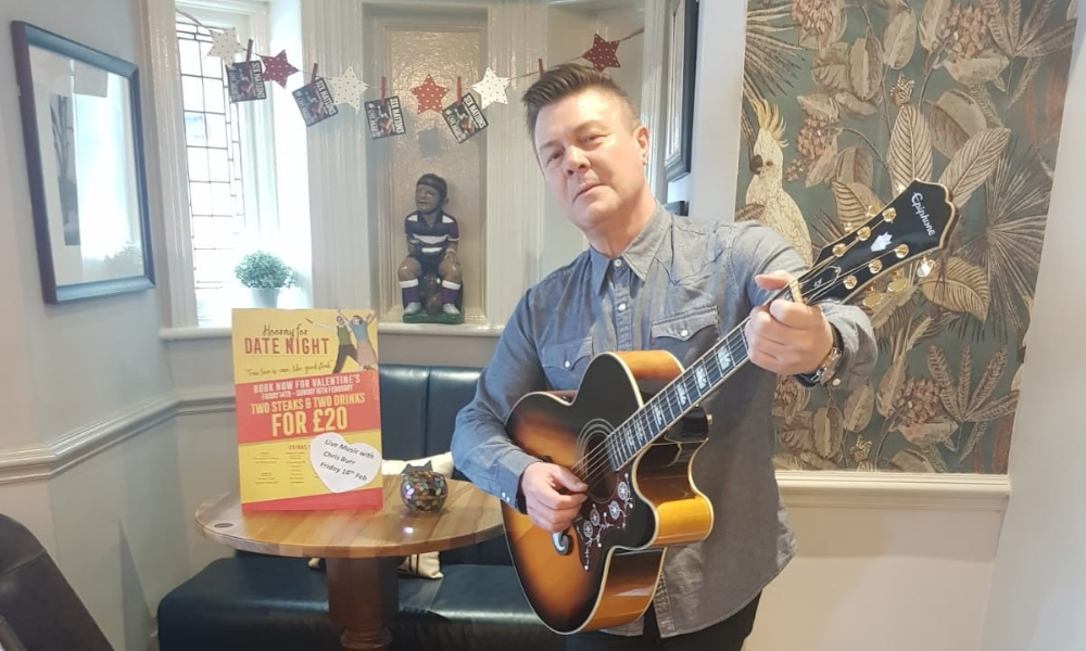 Musician Chris Burr posing with his guitar